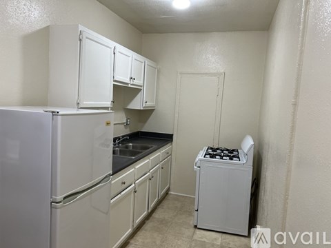 A small kitchen with white appliances and cabinets.