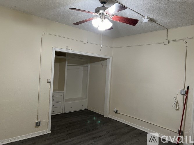 A room with a ceiling fan and a doorway leading to another room.