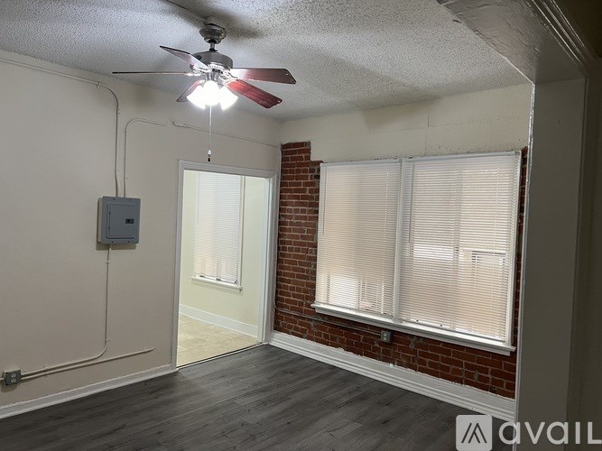 A room with a ceiling fan and a window with blinds.