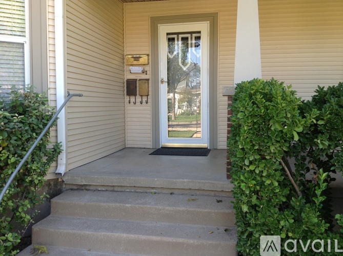 A house entrance with a glass door and a step leading up to it.