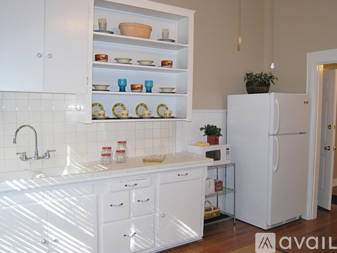 A kitchen with white cabinets and appliances.