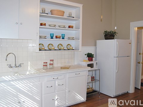 A kitchen with white cabinets and appliances.