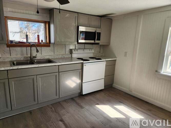 A kitchen with a white stove top oven and a microwave above the stove.