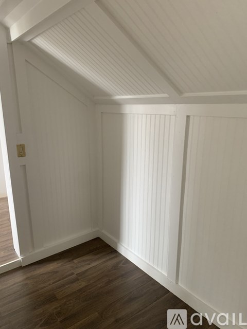 A room with white walls and wooden flooring.