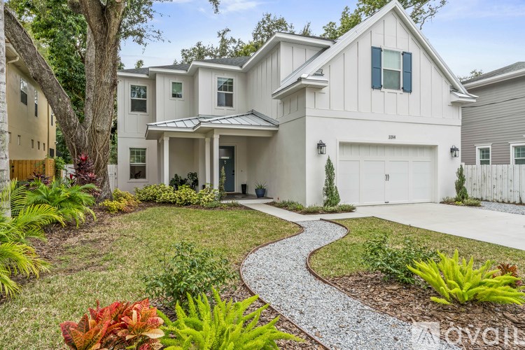 A white house with a gravel pathway leading to the front door.