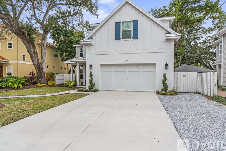 A white house with a garage door and a driveway.