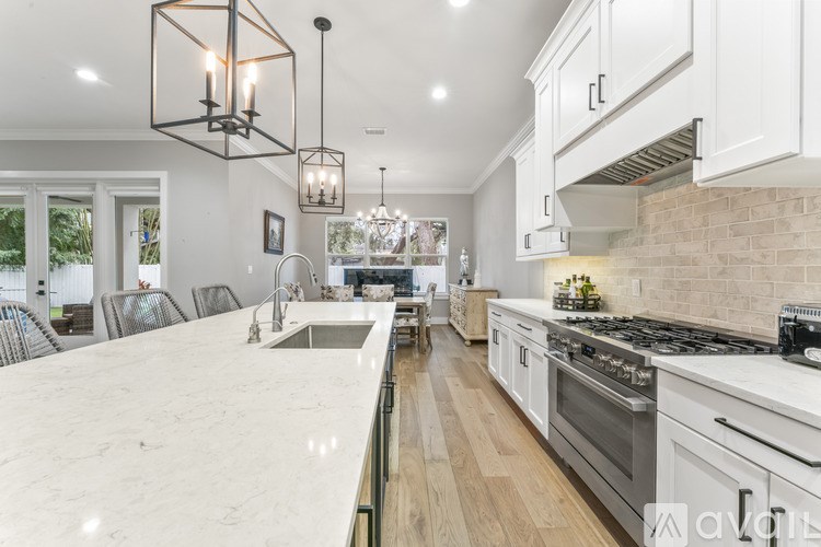 A modern kitchen with white cabinets and a marble countertop.