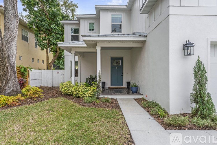 A white house with a black front door and a small porch.
