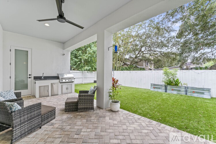 A patio with a table and chairs and a ceiling fan.