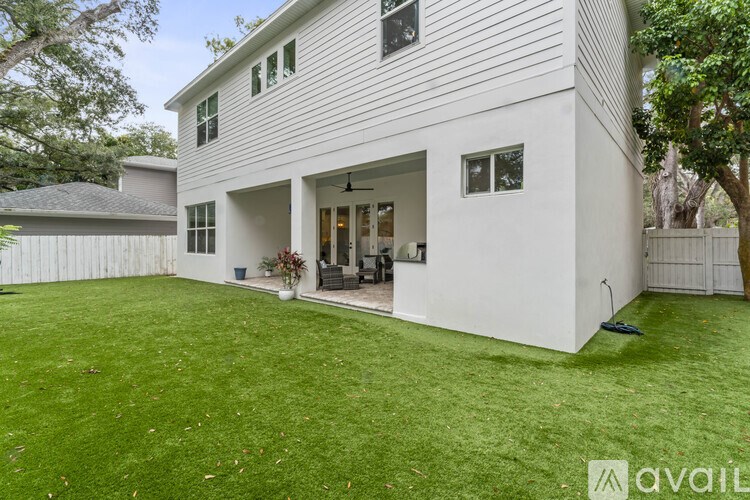 A house with a white exterior and a large lawn in front.