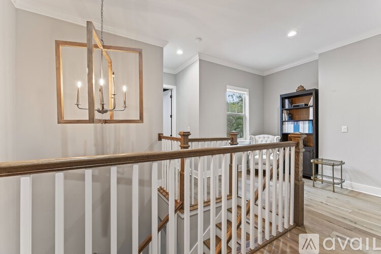 A well-lit room with a staircase and a chandelier.