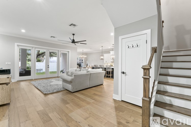 A spacious living room with a staircase on the right side.