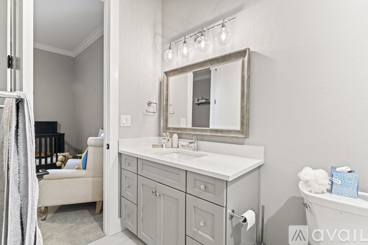 A bathroom with a white counter and a mirror above it.