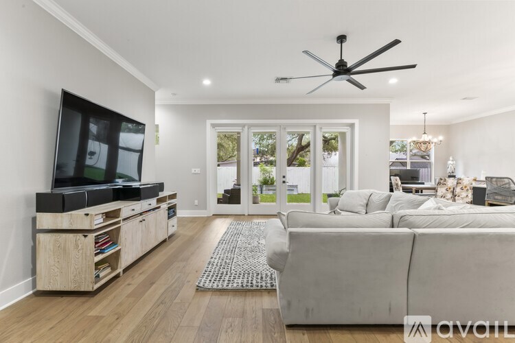 A living room with a television, couch, and sliding glass doors.