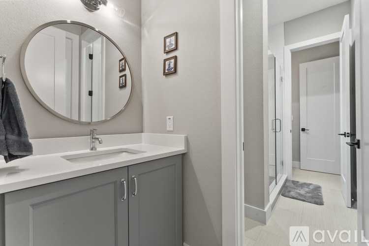 A bathroom with a round mirror and a sink.