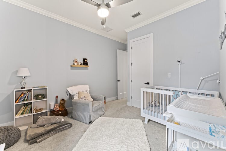 A baby room with a white crib and a grey sofa.