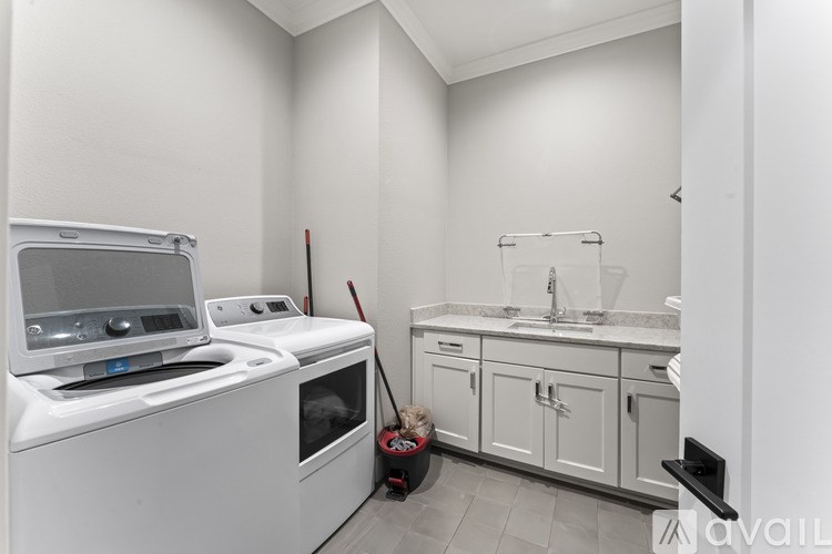 A white kitchen with a white oven and a white sink.
