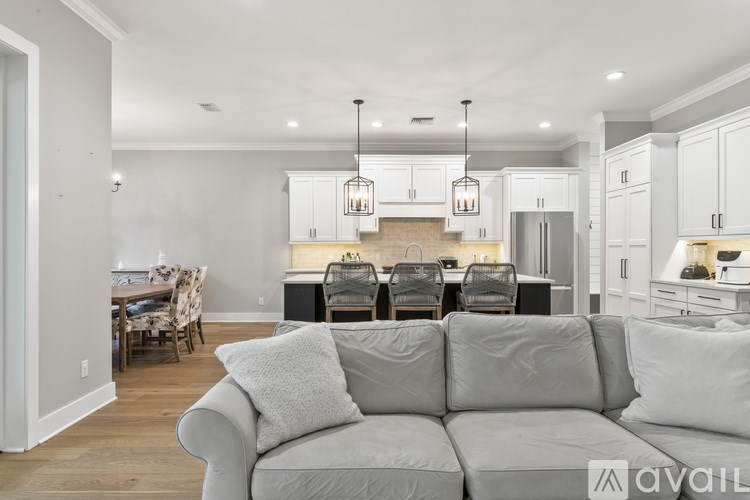 A modern living room with a grey sofa and a dining table set for four.
