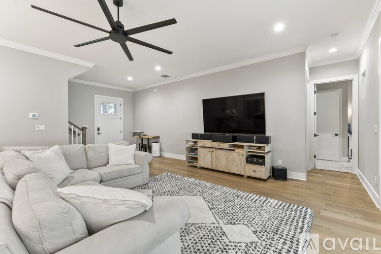 A living room with a grey sofa and a black and white rug.