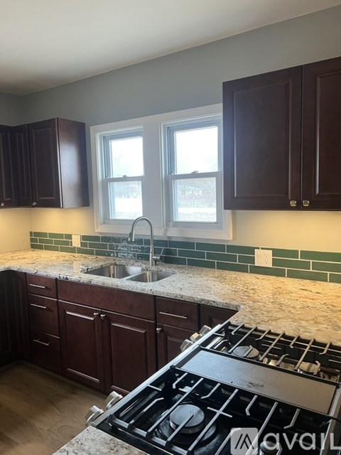 A kitchen with a stove top oven and a sink.