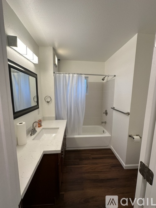A bathroom with a white sink and a white tub.