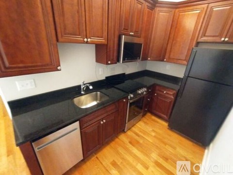 A kitchen with wooden cabinets and black appliances.