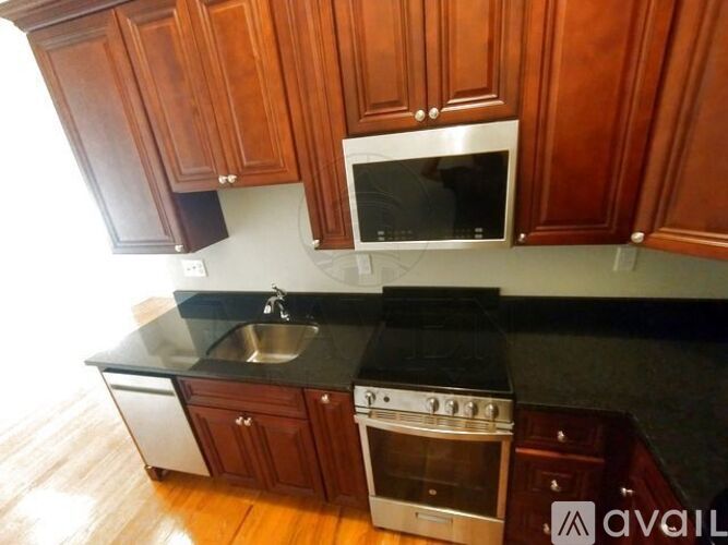 A kitchen with wooden cabinets and a black countertop.