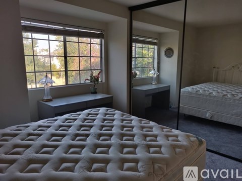 A bedroom with a large bed and a smaller bed in the background.