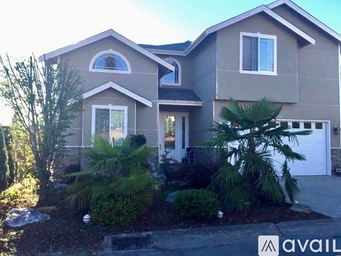 A house with a driveway and landscaping in front.