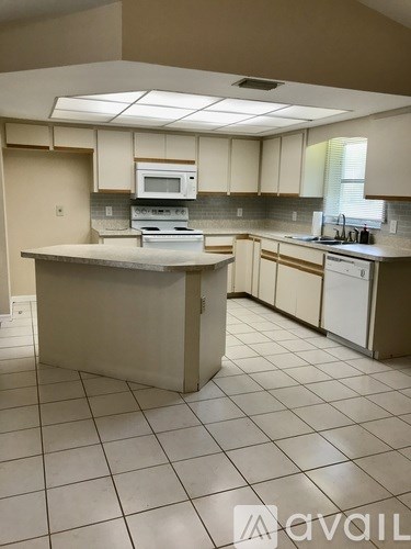 A kitchen with a white counter top and white appliances.