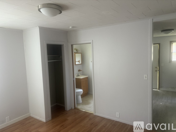 A small bathroom with a toilet, sink and mirror.