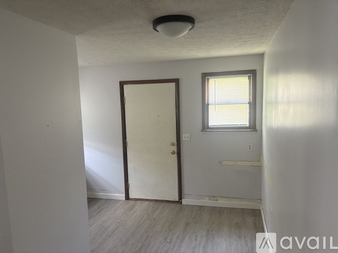 A room with a door, a window, and a light on the ceiling.