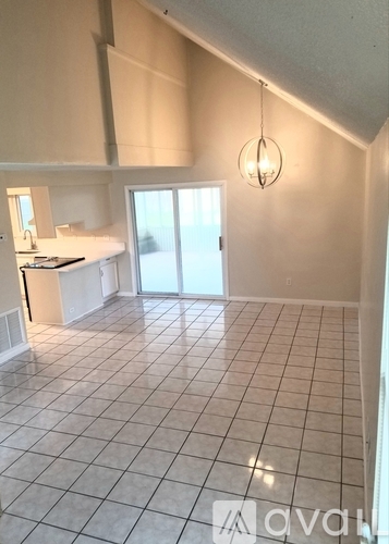 A kitchen with white cabinets and a tiled floor.