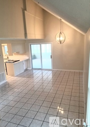 A kitchen with white cabinets and a tiled floor.