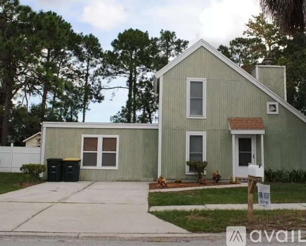 A house with a green exterior is for sale.