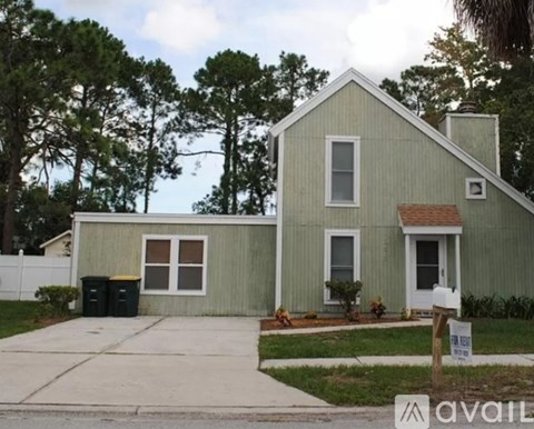 A house with a green exterior is for sale.