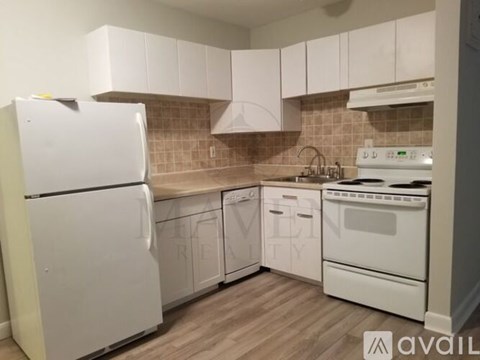 A kitchen with white appliances and cabinets.