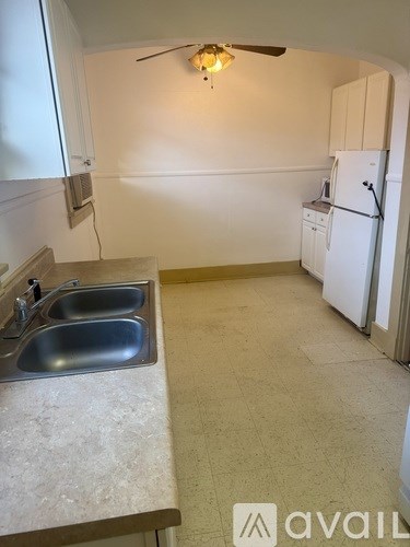 A kitchen with a sink and a refrigerator.