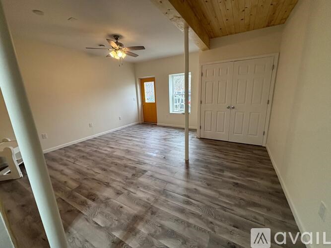 A room with wooden flooring and a ceiling fan.