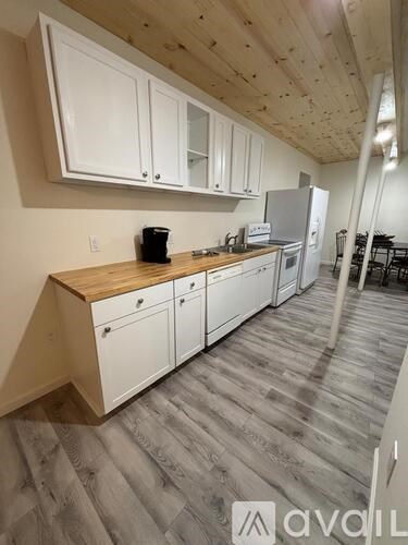 A kitchen with white cabinets and a wooden countertop.