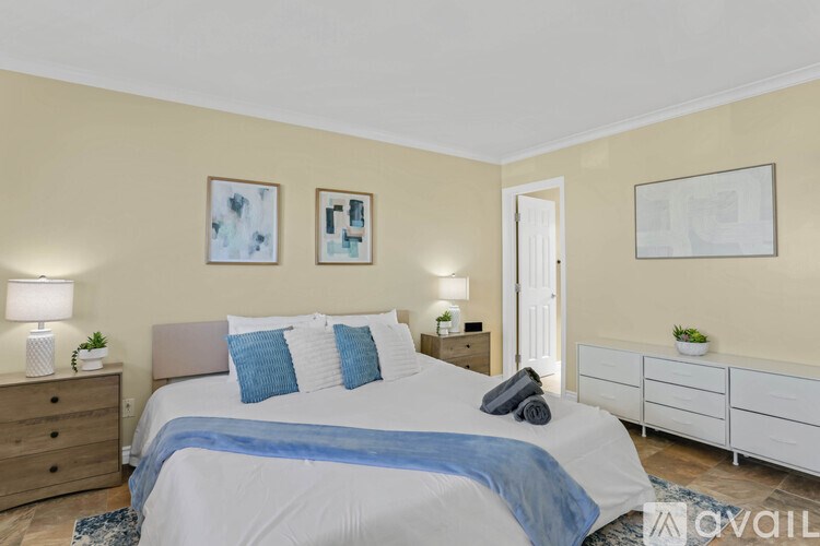 A bedroom with a bed, nightstands, and a cabinet.