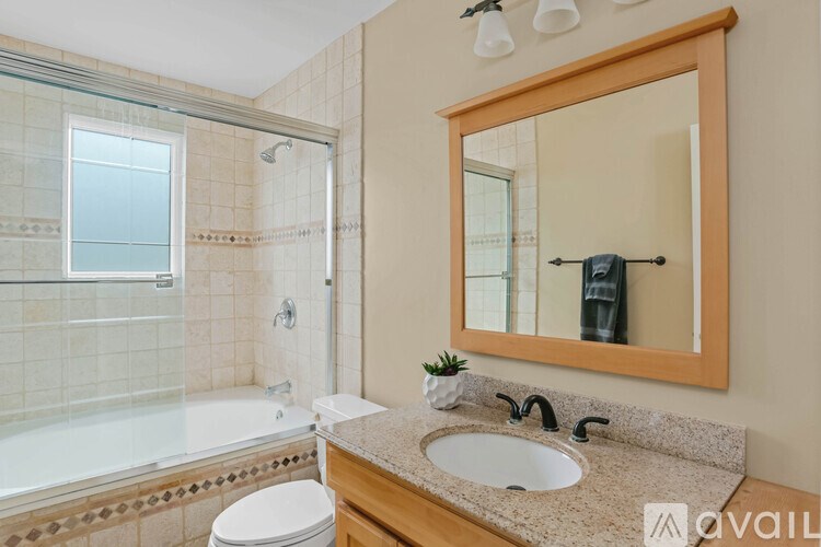 A bathroom with a sink, mirror, and bathtub.