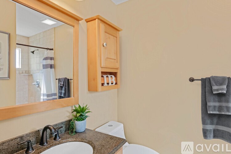 A bathroom with a sink, mirror, and towel rack.