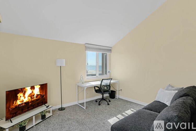 A living room with a fireplace, a desk, and a couch.