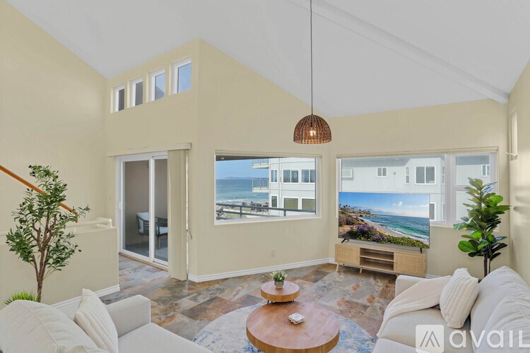 A living room with a view of the ocean through the windows.