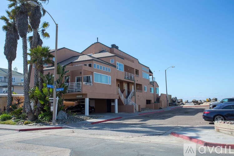 A building with a balcony and a car parked in front.