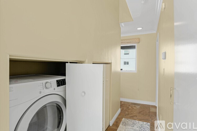 A washing machine is built into a wall in a laundry room.