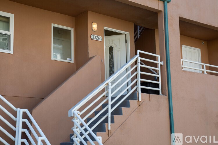 A staircase with a metal railing leads to a door with a number 1526b above it.
