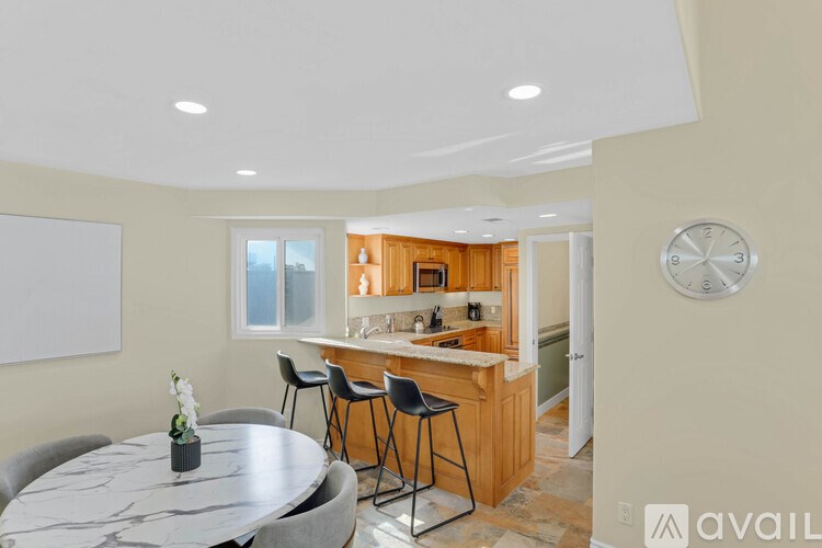 A kitchen with a table and chairs in front of it.
