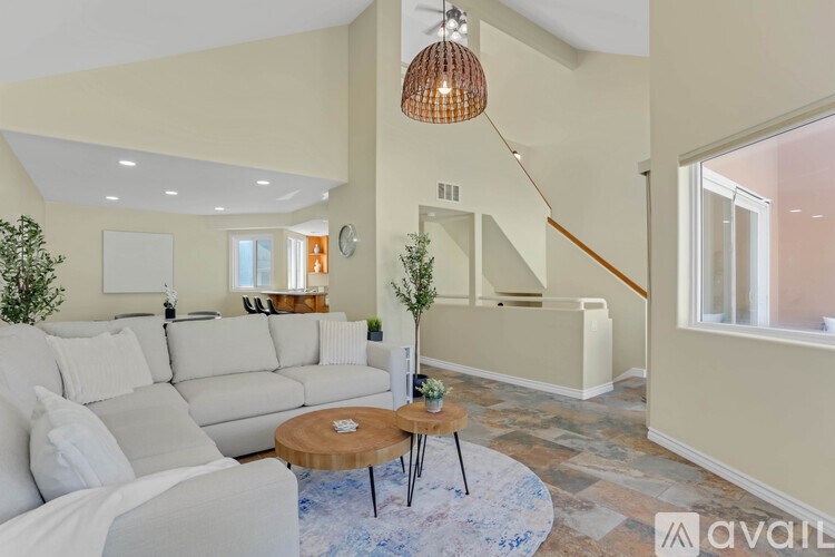 A living room with a white couch and a wooden coffee table.
